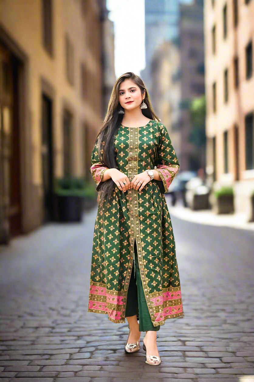 Woman wearing a green traditional outfit with pink patterns on a city street.