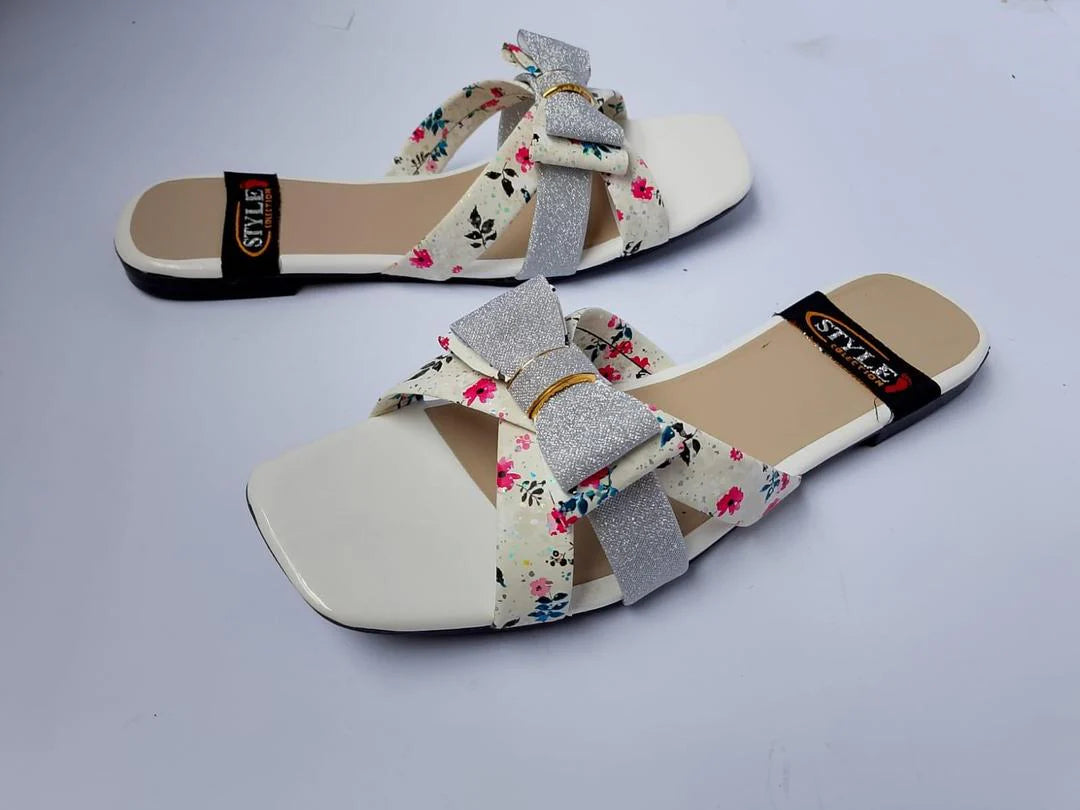 Pair of floral sandals with gray bows on a light gray background