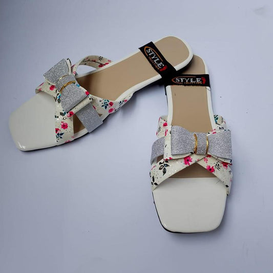 Pair of floral sandals with a decorative bow on a gray background