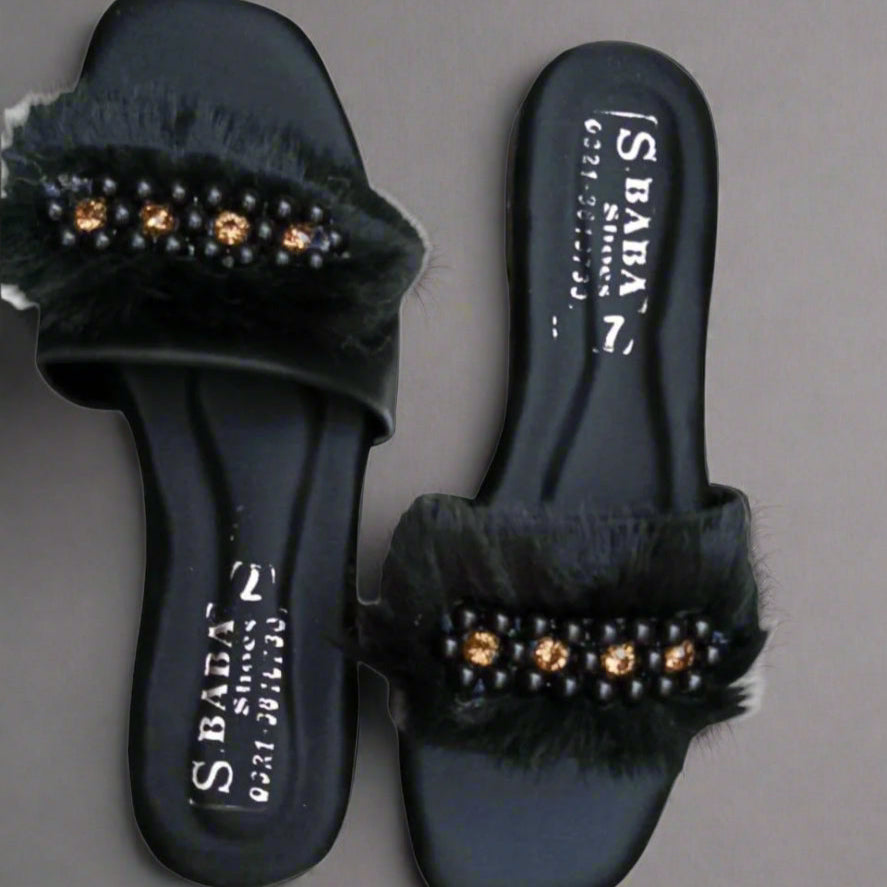 Black slides with fur and gem embellishments on a gray background
