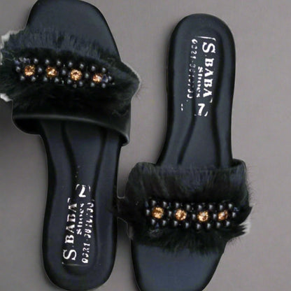 Black slides with fur and gem embellishments on a gray background