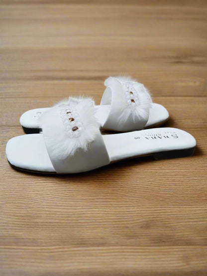 White slippers with fluffy details on a white background